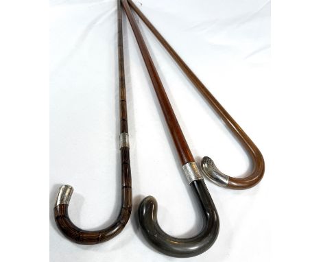 A vintage Malacca cane walking stick with horn loop handle and silver mount, 95cm, and two others.