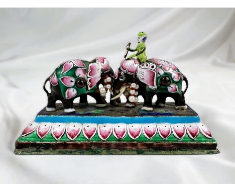 A 19th century Indian white metal and enamel group, featuring clashing elephants set with red cabochon stones etc. length 12 