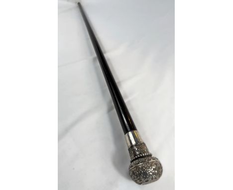 A 19th Century walking stick with tapering ebonised shaft, the ornate white metal knop finial concealing a sovereign dispense