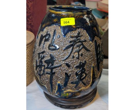 A Japanese stoneware vase of ovoid form with incised calligraphy, square seal mark to base, turned wood support, 31cm.