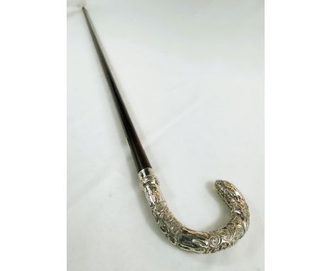 An Edwardian period lady's stick with embossed silver mounted loop handle, London, 1907, 89cm.