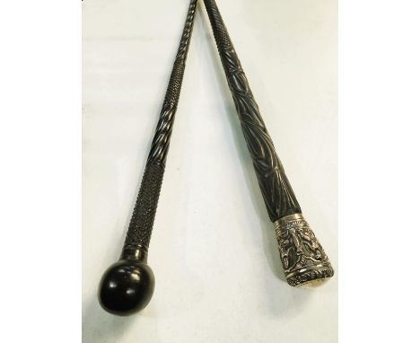 A 19th Century carved Indian ebony walking stick with repousse work silver finial, 87cms, and another (2).