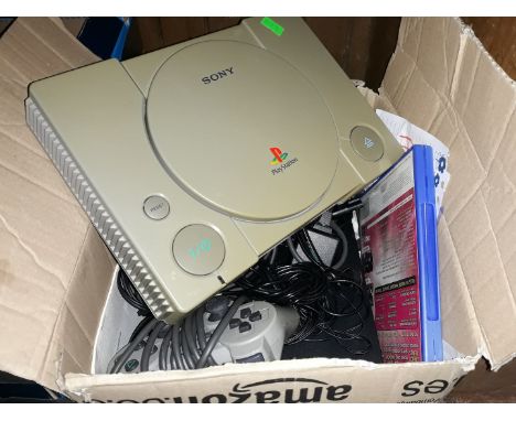 A box containing PS console, a PS2 console, controllers and games 