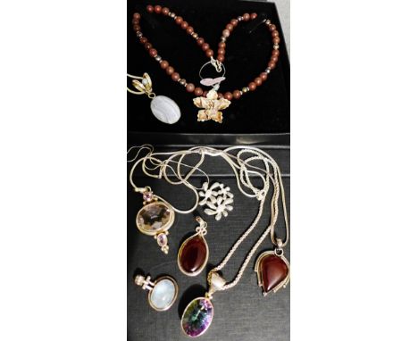 A collection of silver and polished hardstone pendants, with three silver chains, a brown pearl and Thai silver pendant neckl