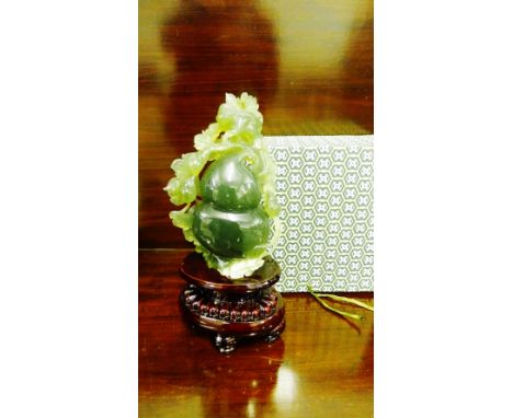 A jade carving depicting a double gourd and leaf on a shaped base, 29cm