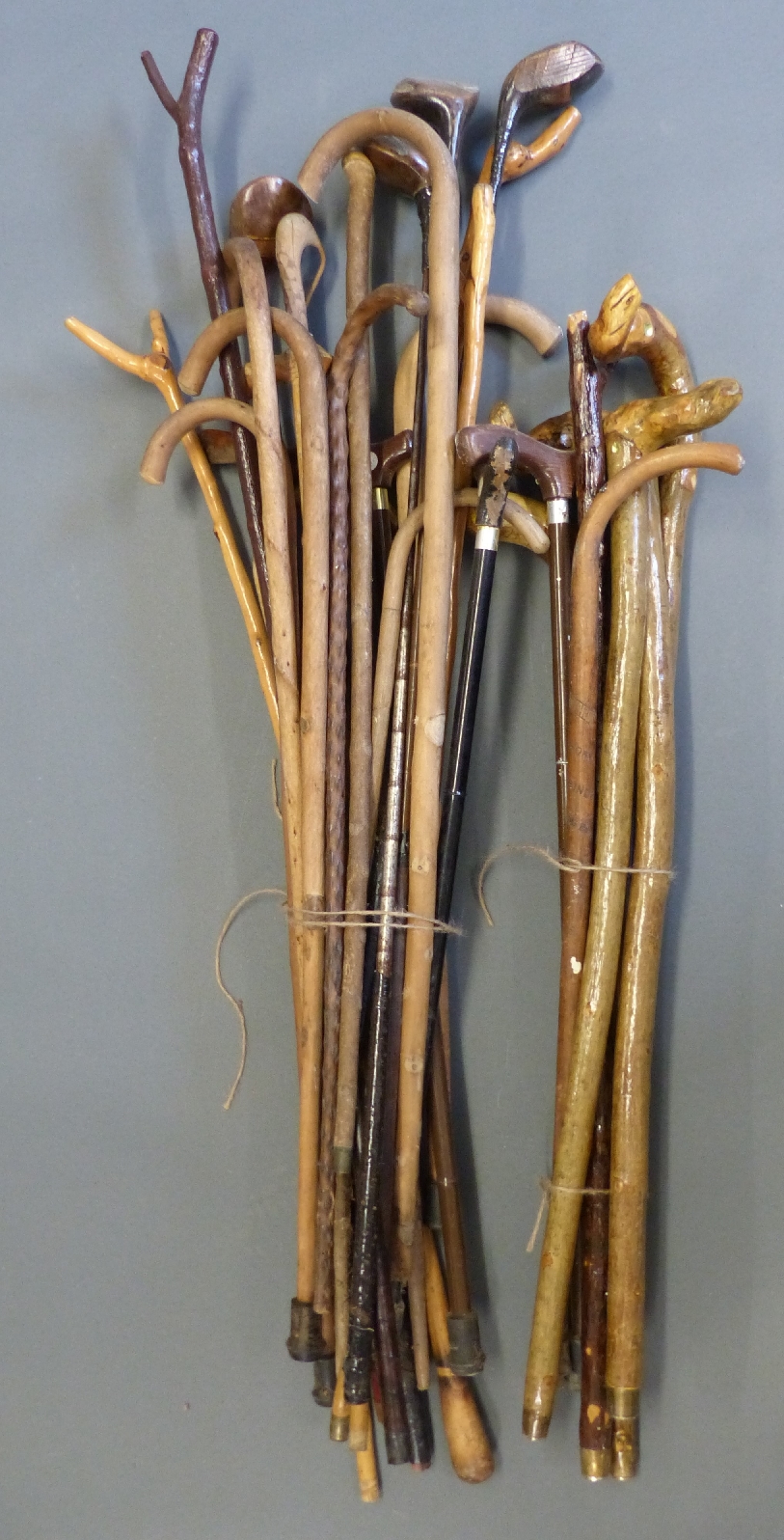 A large collection of walking sticks, thumb sticks, vintage golf clubs etc