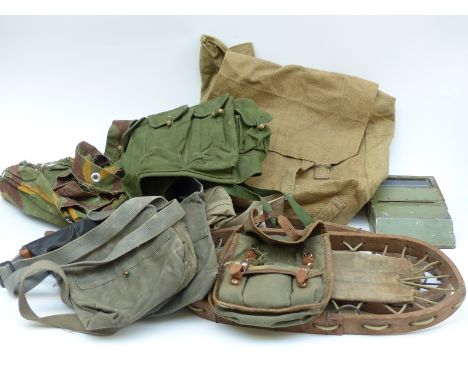 An assortment of military equipment to include webbing and ammunition pouches, snow shoes and prismatic AFV optic or periscop