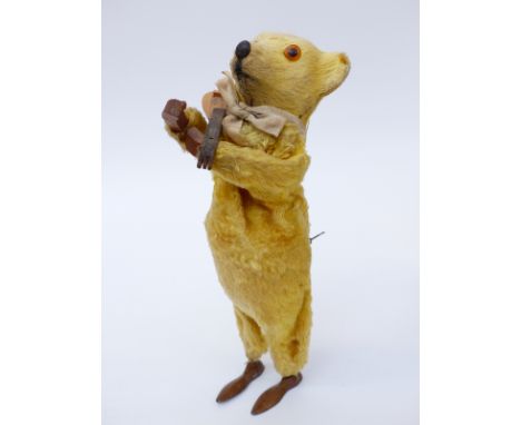 Clockwork tinplate bear playing a mandolin with golden fur and internal music box, 17cm tall. 