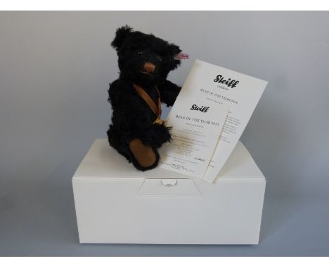 Steiff Teddy Bear of the Year 2014 with black brown mohair, gold plated pendant, blue ribbon and jointed limbs, limited editi