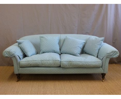 A Howard style sofa raised on turned legs, length 220cm