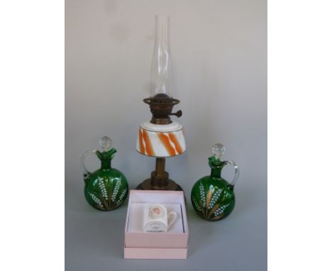 An oil lamp and two enamelled glass decanter jugs