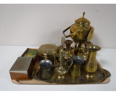 A tray containing assorted brass ware including a spirit kettle on stand, measures, Eastern style miniature tea pot, together