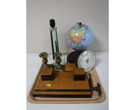 A tray containing art deco desk stand, an art deco bakelite table lamp, a metal Chad Valley globe, brass candlesticks, travel