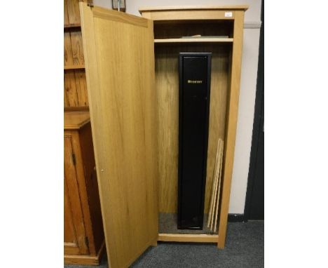 A fortify three gun, shotgun cabinet, with two keys, contained within a light oak cabinet