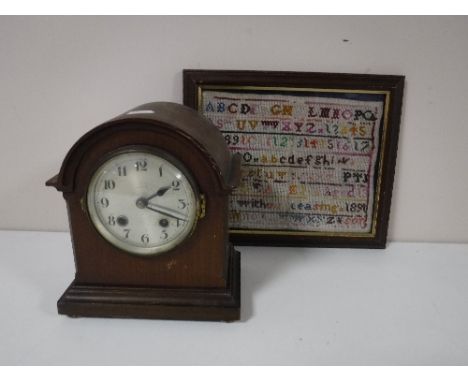 A framed late nineteenth century sampler, together with a mahogany mantel clock 