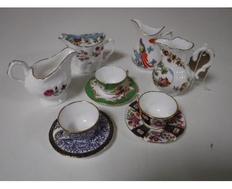 Four Royal Worcester milk jugs and three Royal Worcester miniature cups and saucers 