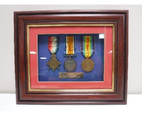 A framed set of three WWI medals presented to John Simm of Durham Light Infantry 
