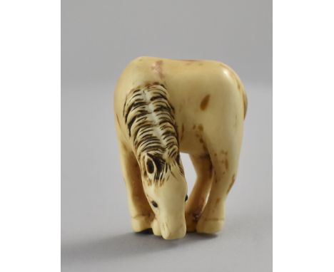 {Netsuke.} Grasendes Pferd. Hirschhorn mit eingelegten Augen. Japan. H 4,5 cm