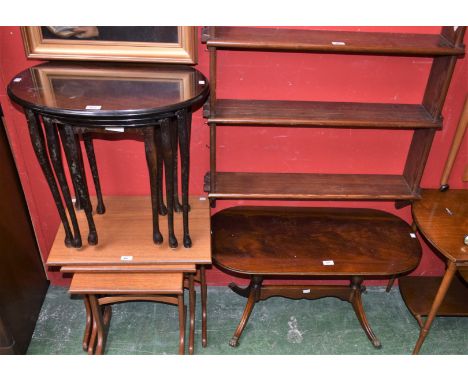 A mid 20th century teak nest of three tables; another; a reproduction mahogany coffee table, elliptical top supported by two 