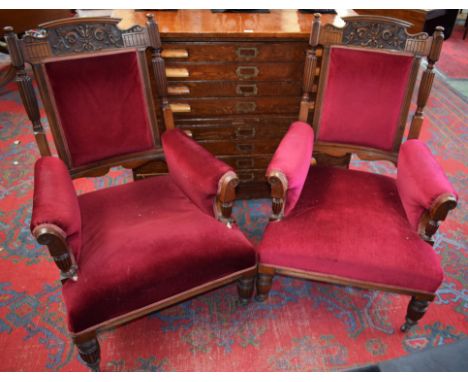 A pair of 19th century mahogany library chairs, each with stepped and shaped cresting rail carved and applied with stiff and 