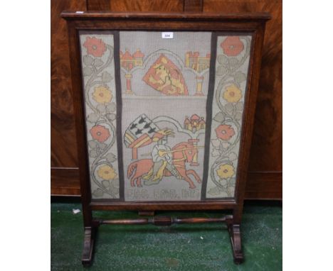 An early 20th century oak framed tall fire screen, inset Heraldic tapestry panel, dated 1915