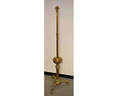 A 20th century brass standard lamp, telescopic column, gadrooned 'font', triform base, lion paw feet