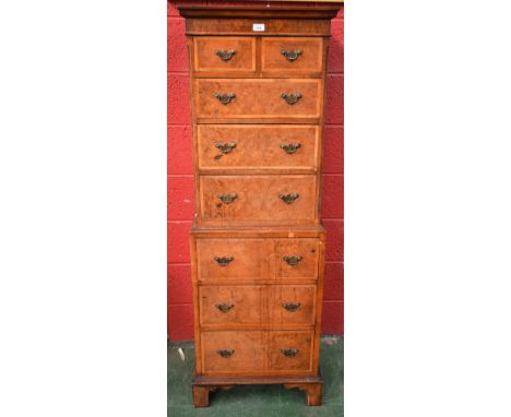 A 20th century walnut and mahogany chest on chest, outswept moulded cornice above two short and three graduated long drawers,