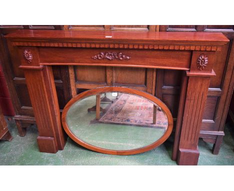 A Neoclassical design mahogany fire surround; a 1920's mahogany oval mirror (2)