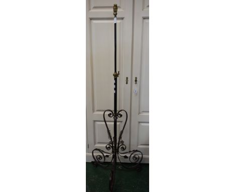 An Arts and Crafts style metal standard lamp, telescopic column, scroll triform base, extends to 200cm high