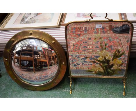 An Art Nouveau brass mirrored firescreen, hand painted; a circular convex mirror, brass frame, 52cm diameter (2)
