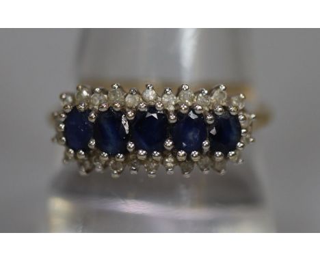 9ct gold dress ring set with five sapphires and diamond chips.  2.5g approx.  Ring size R.  (B.P. 21% + VAT) 