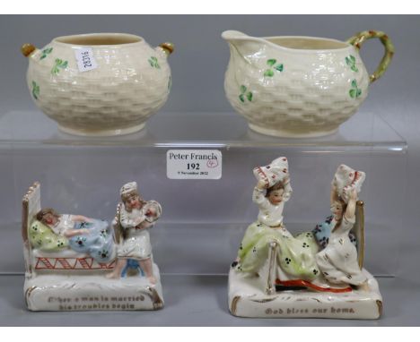 Two Belleek Irish porcelain ceramic items, to include: sucrier, milk jug, together with two German Fairings.  (4)  (B.P. 21% 