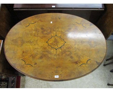 19th Century burr walnut oval inlaid loo table on four column support with swept carved legs and brass and ceramic casters, 3