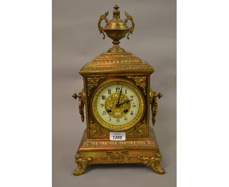 Late 19th Century gilt brass mantel clock of ornate design, the rectangular case with an urn surmount and shaped side handles