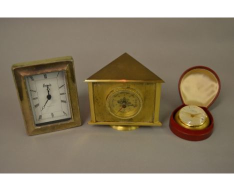 Looping gilt metal eight day travel clock in a leather case, together with a French revolving desk clock / thermometer / baro