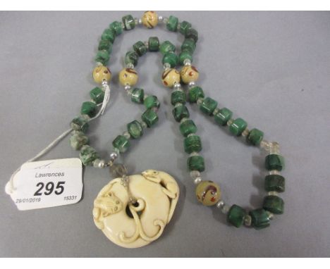 Late 19th / early 20th Century Japanese carved ivory netsuke, mounted as a pendant on a jade and glass bead necklace CONDITIO