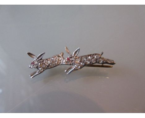 Yellow metal diamond and ruby set bar brooch in the form of two running rabbits