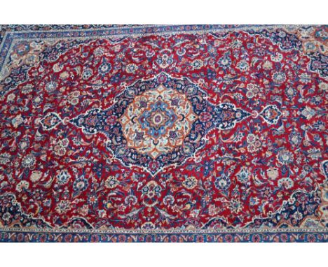 Good quality Tabriz carpet with a lobed medallion and floral design on a red ground with borders, 12ft x 9ft approximately CO