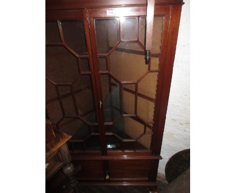 20th Century mahogany floor standing corner cabinet, having moulded cornice above two bar glazed doors with adjustable shelve