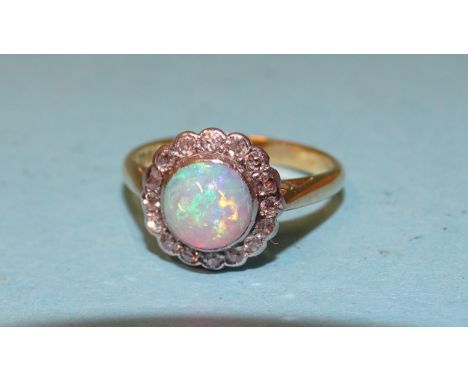 An opal and diamond cluster ring set a round opal within a border of sixteen 8/8-cut diamonds, in 18ct yellow gold mount, siz