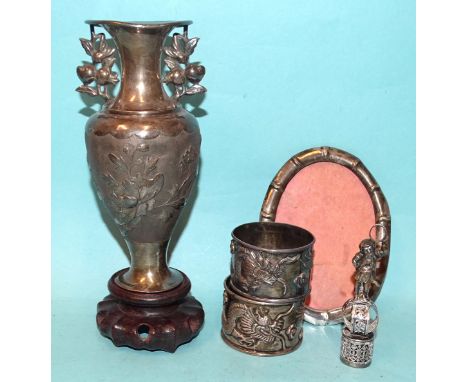 A Chinese silver Tai Hua napkin ring embossed with a dragon, another similar, a Chinese white metal vase on stand, 17cm overa