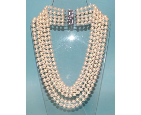 A late-20th century necklace of five strands of uniform cultured pearls, with white gold pearl-set clasp marked 14K.W.G, pear