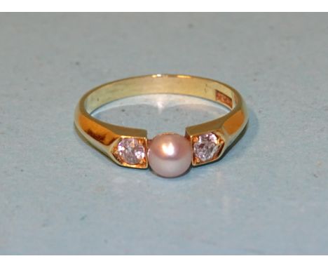 An 18ct yellow gold ring set a cultured pearl between two old brilliant-cut diamonds, (0.1ct each approximately), K½, 2.7g. 