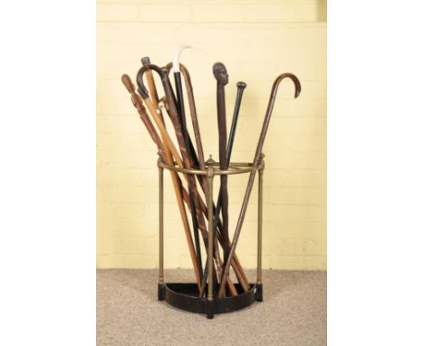 A VICTORIAN BRASS AND CAST IRON STICK STAND with turned finials and black painted drip tray, 58cm high x 40cm wide; together 