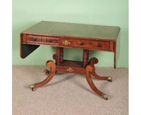 A REGENCY ROSEWOOD SOFA TABLEwith two single drawers, brass inlaid top on twin shaped legs to brass castors, 72cm x 105cm