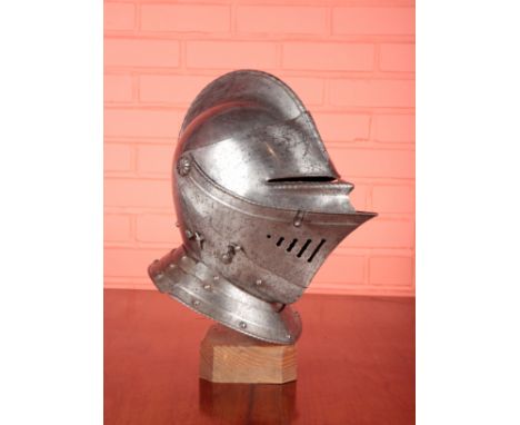 A 17TH CENTURY EUROPEAN CLOSE HELMET with skull formed in one piece, rope twist to comb and plume holder, 35cm high