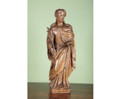 A CARVED LIMEWOOD FIGURE OF ST CATHERINE OF ALEXANDRIApossibly German, 17th century, carved with feathered quill in hand, on 