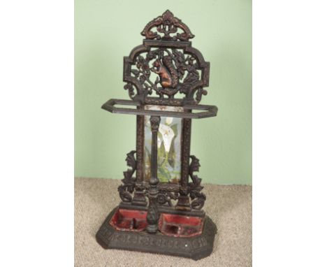 A VICTORIAN CAST IRON TWO DIVISION STICK STANDthe back cast with a squirrel above a panel painted with lilies, on an angled b