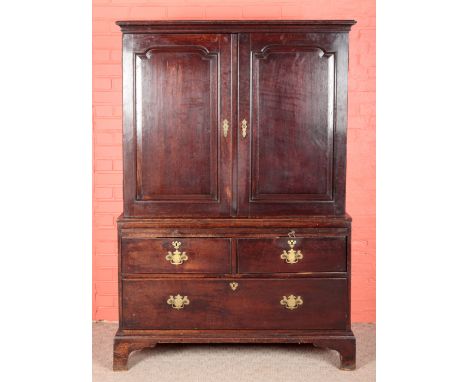 A GEORGE III OAK LINEN PRESS the upper section with a moulded cornice over panelled cupboards opening to a shelved interior, 