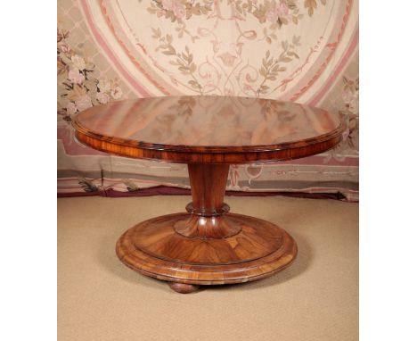 A WILLIAM IV ROSEWOOD CENTRE TABLE the circular tilt-top with a moulded outside edge, on a tapered plinth to a domed base and